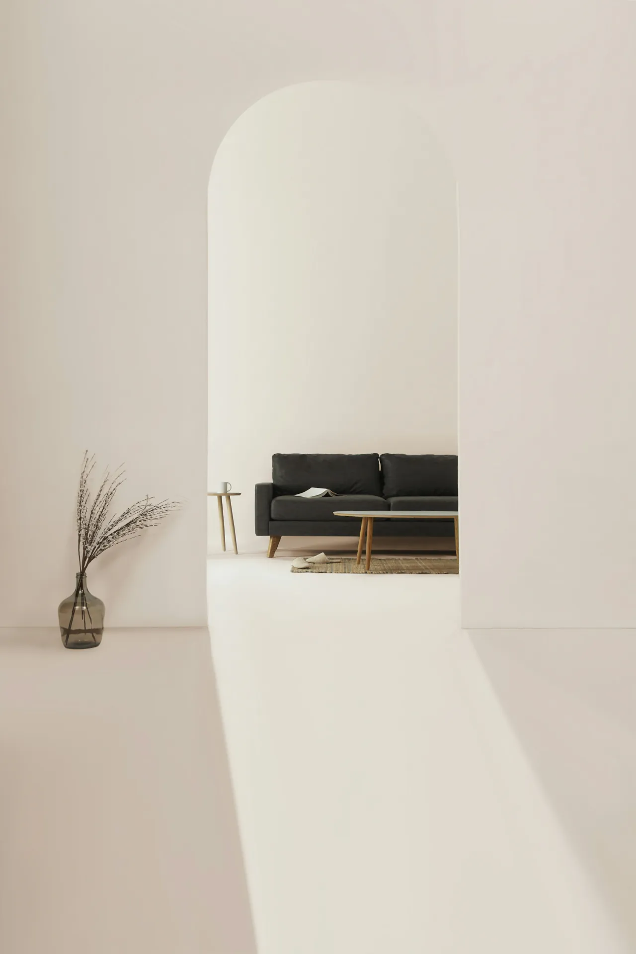An arched doorway onto a room with a low black sofa