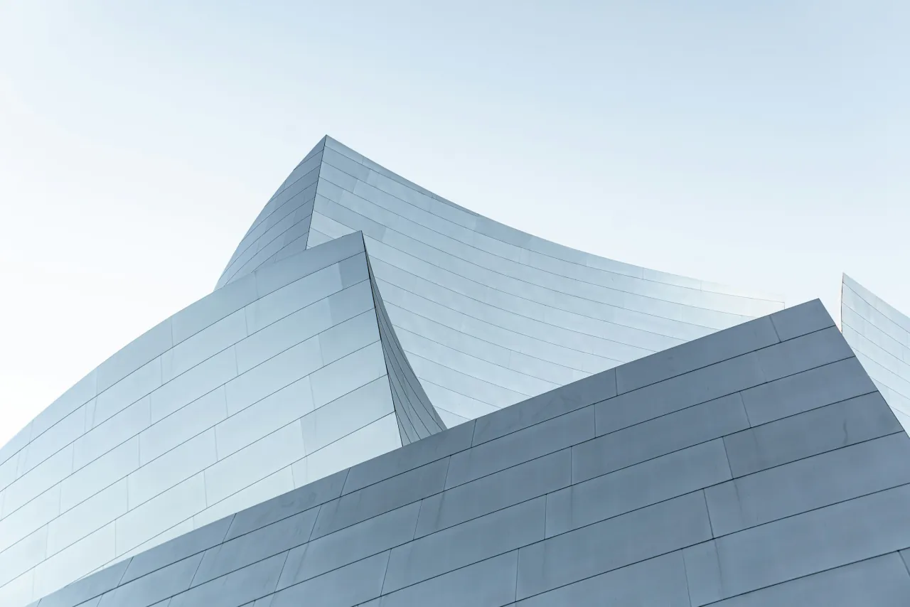 Folded metal roof peaks against a pale blue sky