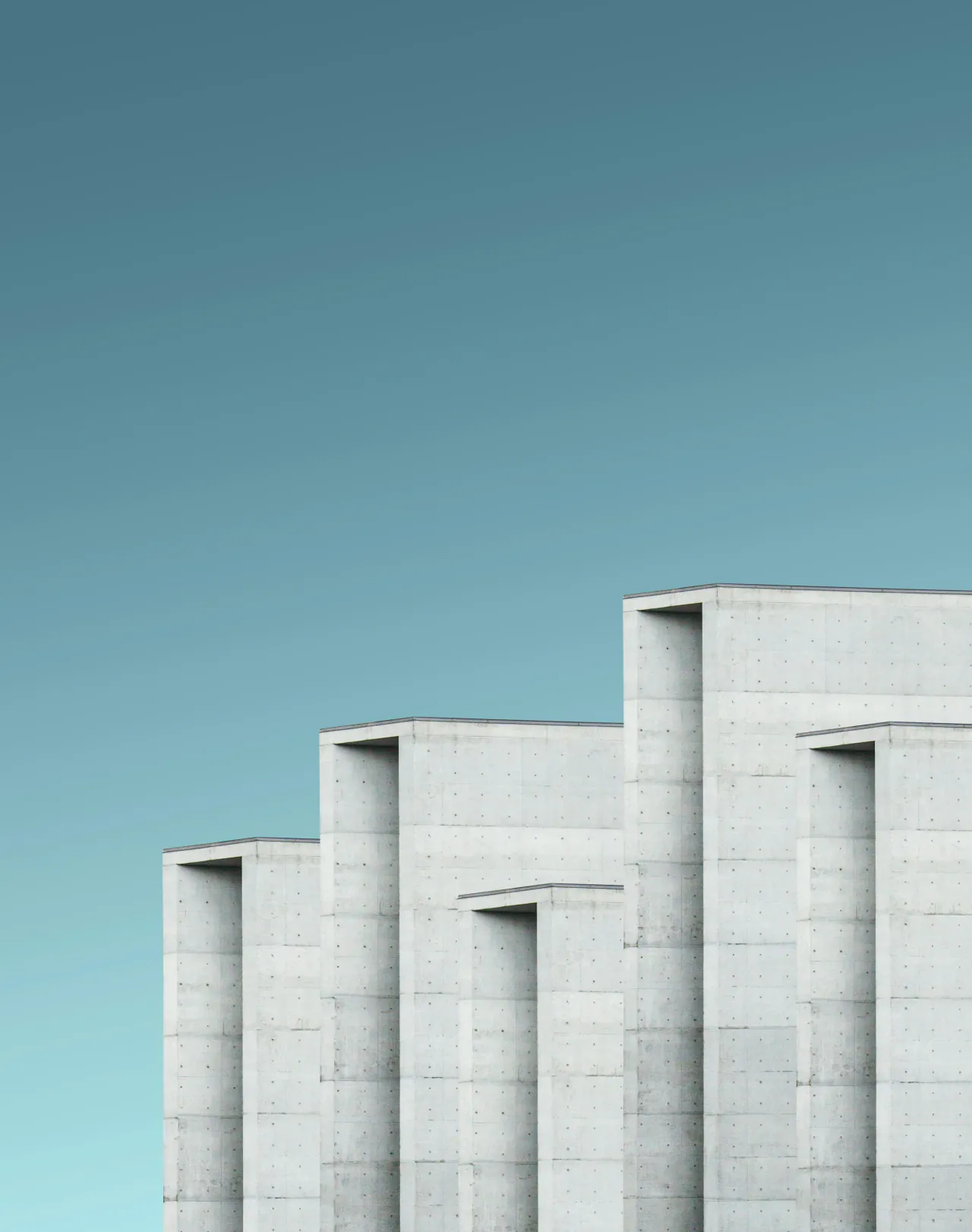 Stepped white towers against a teal sky