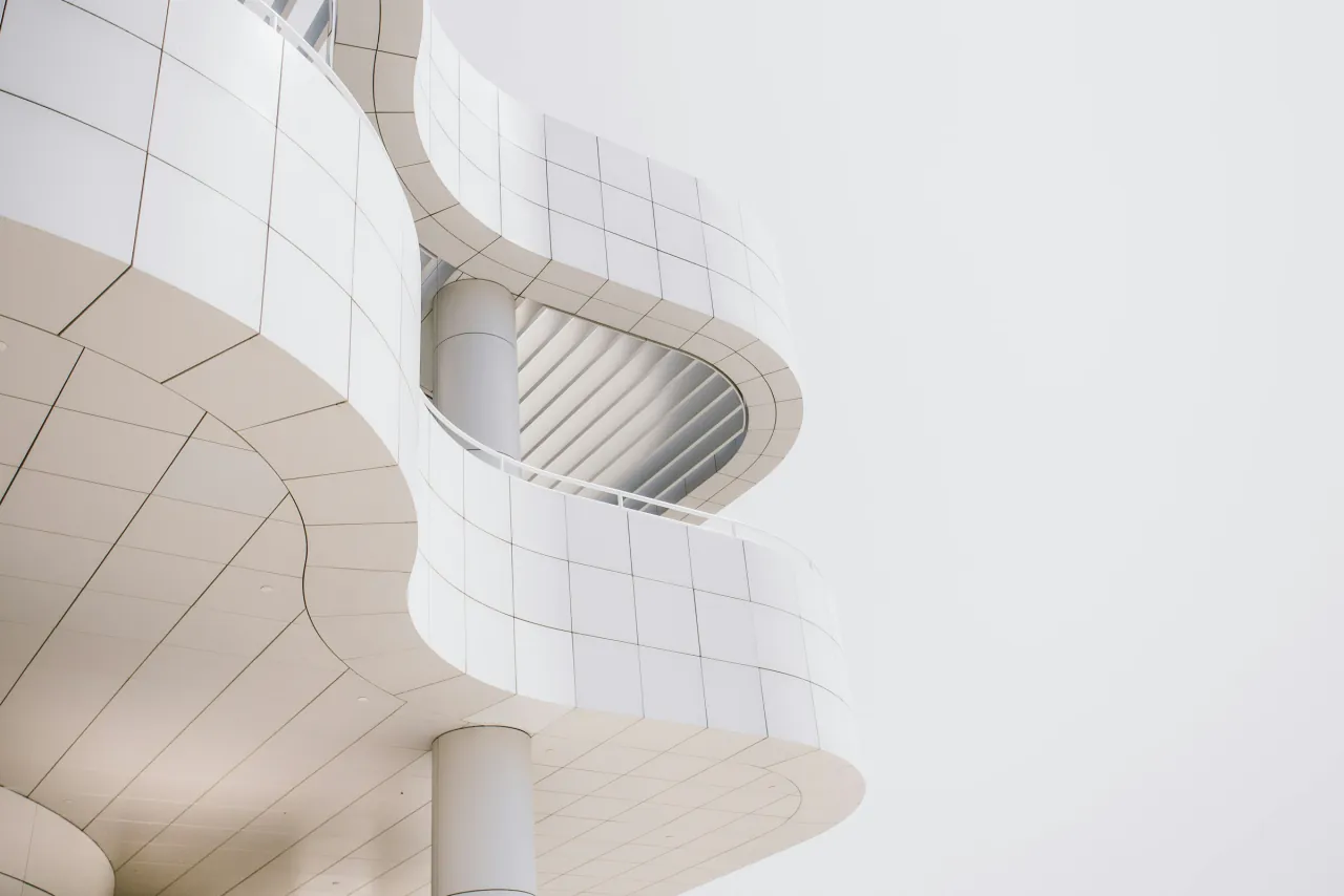 A curving white facade wrapped around a rounded window